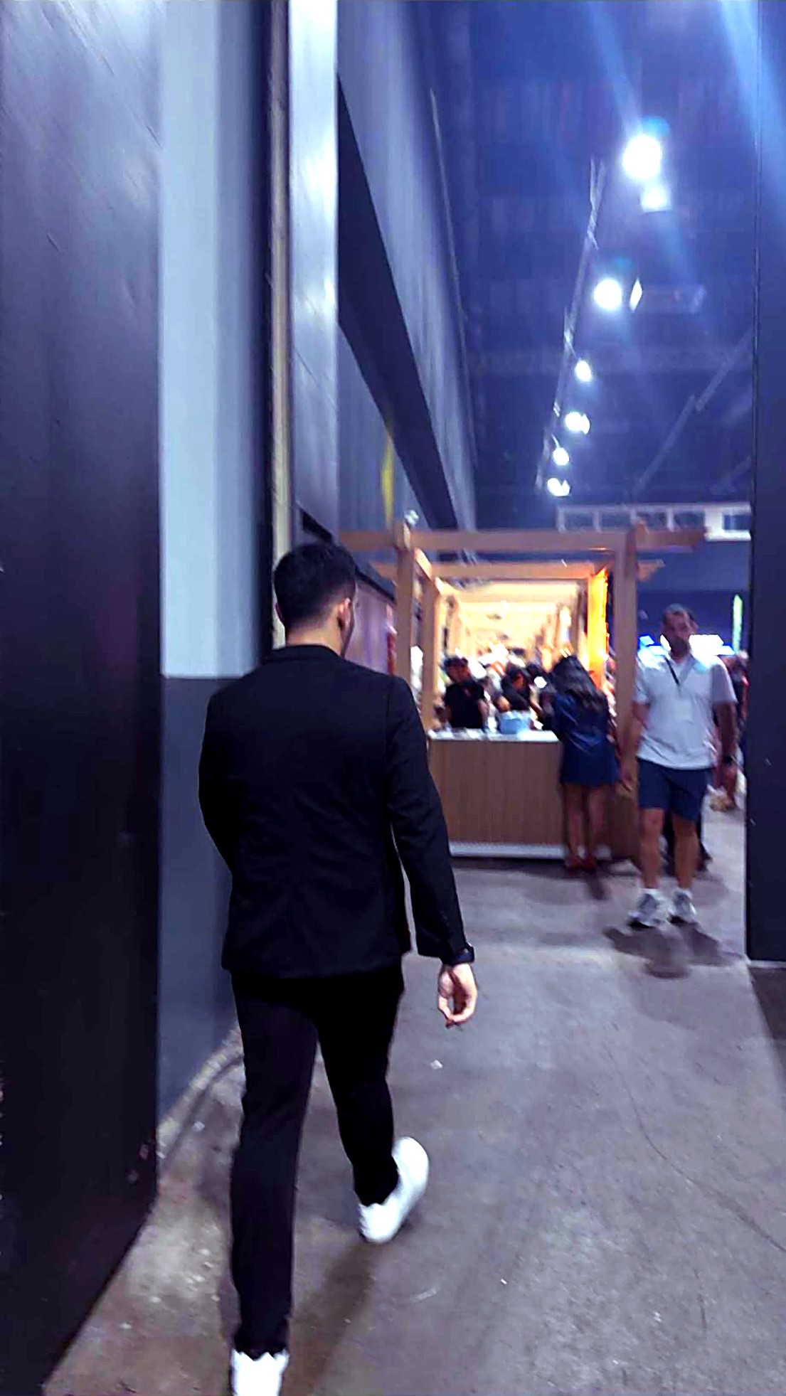 Richard caminando entre stands de un festival